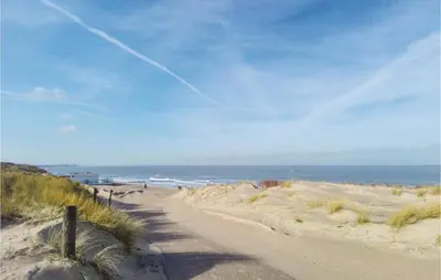 a dirt road leading to a beach with the ocean at Dophuisje in Egmond aan Zee