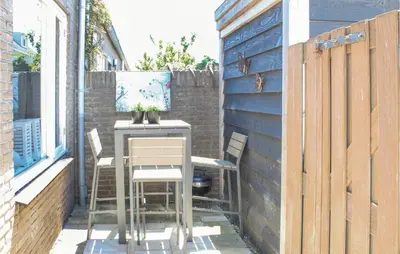a small patio with a table and chairs on a building at Dophuisje in Egmond aan Zee