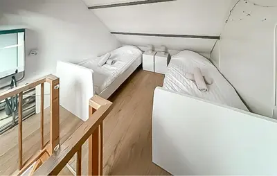 a small room with two beds and a tv at Dophuisje in Egmond aan Zee