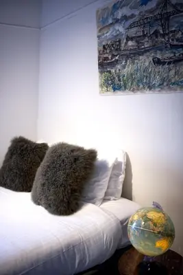 a bed in a room with a painting on the wall at Cozy Pijp Apartment Amsterdam in Amsterdam