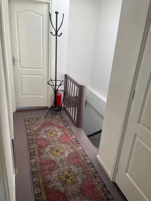 a hallway with a rug next to a door with a stairwell at Cozy Pijp Apartment Amsterdam in Amsterdam