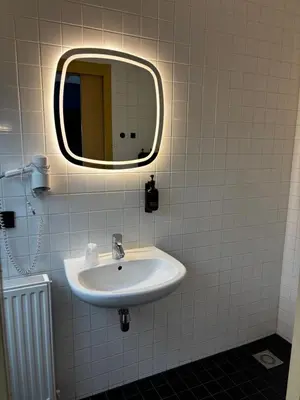 a bathroom with a sink and a mirror at Hotel Oostereiland in Hoorn