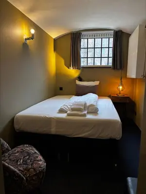 a bedroom with a large white bed with a window at Hotel Oostereiland in Hoorn