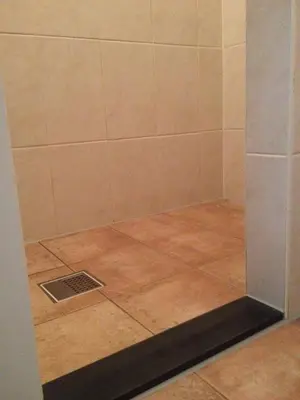a shower with a glass door and a tile floor at Sint Nicolaashoeve in Nieuwveen