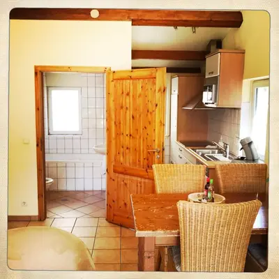 a kitchen with a table and chairs in a kitchen at De Munnik in Camperduin