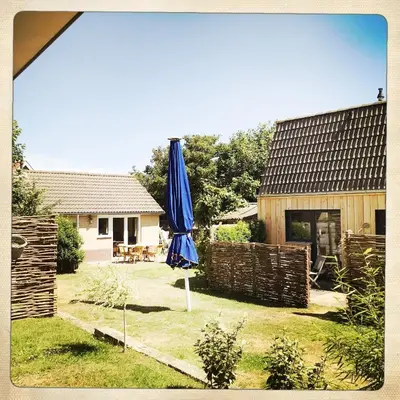 a blue umbrella in the yard of a house at De Munnik in Camperduin