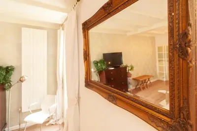 an antique mirror hanging on a wall in a living room at CASASdeCASPER - Studio Alkmaar in Alkmaar