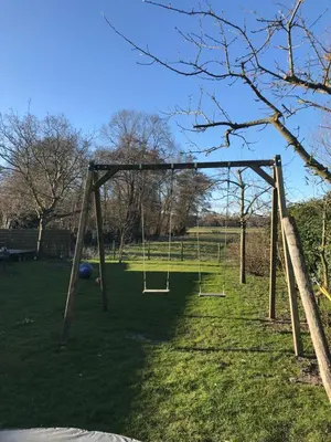 an empty swing set in a grassy field at de Ark in Schoorl