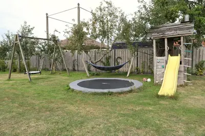 a playground with a hammock and a swing set at de Ark in Schoorl