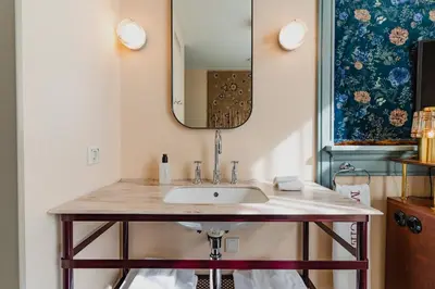 a bathroom with a sink and a mirror at Hotel Mercier in Amsterdam
