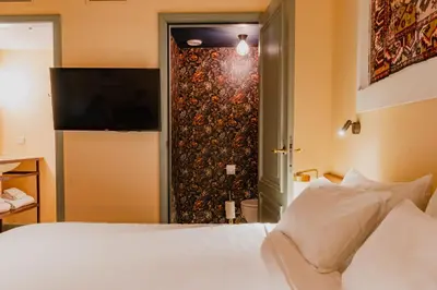 a bedroom with a white bed and a sliding glass door at Hotel Mercier in Amsterdam