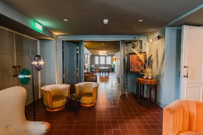 a hallway with chairs and a living room at Hotel Mercier in Amsterdam