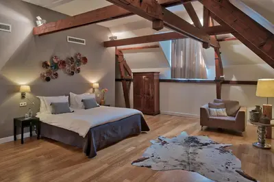 a bedroom with a large bed and a chair at Hotel ML in Haarlem