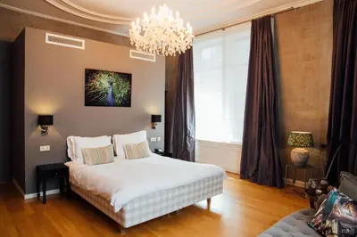 a bedroom with a bed and a chandelier at Hotel ML in Haarlem