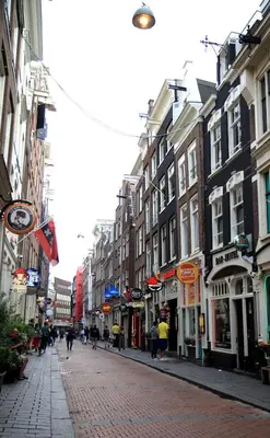 a city street with buildings and people walking down a street at Hotel 55 - City Centre in Amsterdam