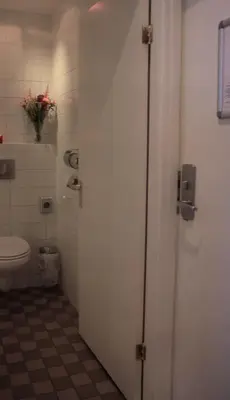 a bathroom with a toilet and a door with a toilet at Hotel 55 - City Centre in Amsterdam