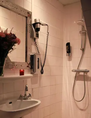 a bathroom with a shower and a sink at Hotel 55 - City Centre in Amsterdam