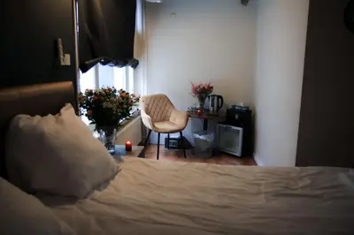a bedroom with a bed and a chair and a window at Hotel 55 - City Centre in Amsterdam