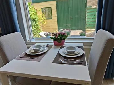 a table with two chairs and a white table and a window at Yuki in Zandvoort
