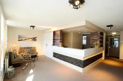 a living room with a fireplace in a house at Hotel De Boei in Egmond aan Zee