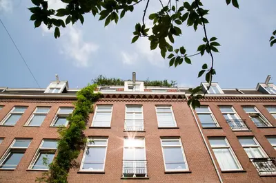 a red brick building with a green ivy on it at BB Museumquarter in Amsterdam