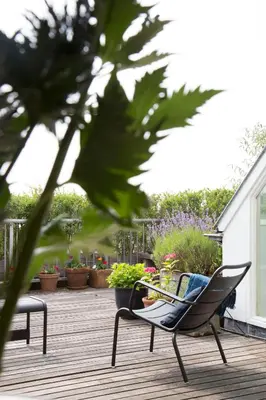 a chair on a deck with plants and flowers at BB Museumquarter in Amsterdam