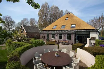 a house with a table and chairs in a yard at Shepherds House B&B in Limmen