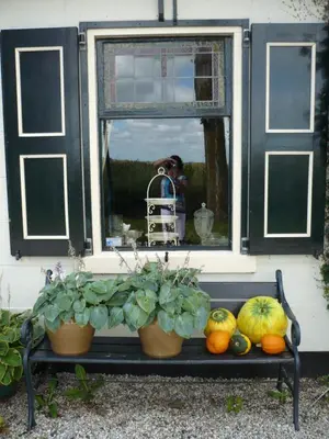 a man taking a picture of a window with fruits and vegetables at Shepherds House B&B in Limmen