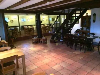 a restaurant with tables and chairs and a staircase at Shepherds House B&B in Limmen