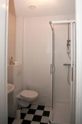 a white bathroom with a toilet and a shower at Shepherds House B&B in Limmen