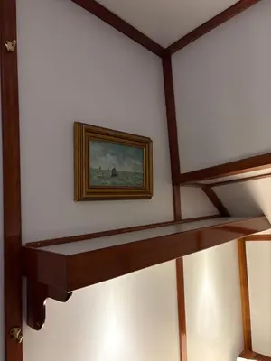 a painting on a wall with a wooden shelf at Hotelboot Zwaan in Amsterdam