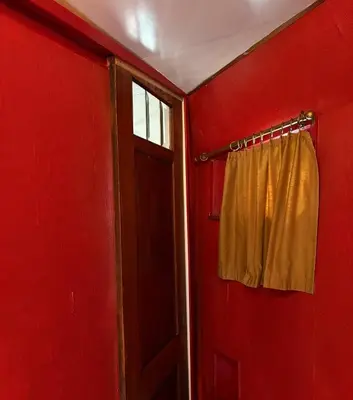 a red room with a window and a curtain at Hotelboot Zwaan in Amsterdam