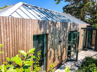 a wooden house with a metal roof at Zandvoort Lodge in Zandvoort