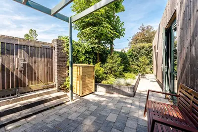 a patio with a bench and a fence at Zandvoort Lodge in Zandvoort
