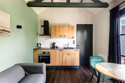 a living room with a couch and a kitchen at Zandvoort Lodge in Zandvoort