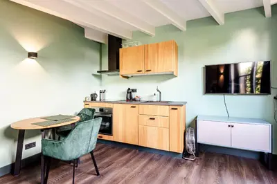 a kitchen with a table and chairs and a table and a tv at Zandvoort Lodge in Zandvoort