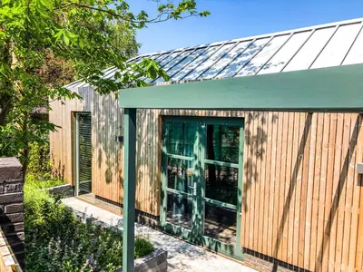 a wooden house with a green roof at Zandvoort Lodge in Zandvoort