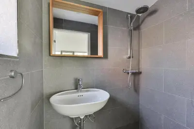 a bathroom with a white sink and a mirror at Beach House Amsterdam Lohman in Zandvoort