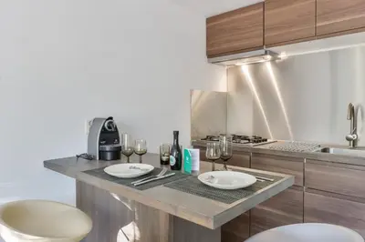 a kitchen counter with two plates and wine glasses at Beach House Amsterdam Lohman in Zandvoort