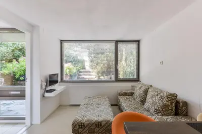a living room with a couch and two windows at Beach House Amsterdam Lohman in Zandvoort