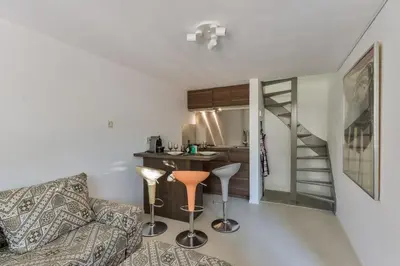 a living room with a couch and a table and a kitchen at Beach House Amsterdam Lohman in Zandvoort