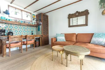 a living room with a couch and a table at CASA KAREN - Houseboat studio with private terrace in Amsterdam