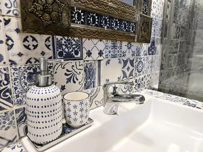 a bathroom sink with a blue and white tiled wall at CASA KAREN - Houseboat studio with private terrace in Amsterdam