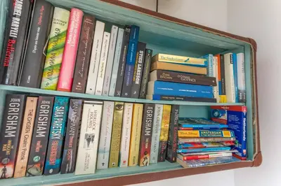a book shelf filled with lots of books at CASA KAREN - Houseboat studio with private terrace in Amsterdam