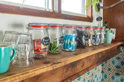 a row of jars sitting on a wooden shelf at CASA KAREN - Houseboat studio with private terrace in Amsterdam
