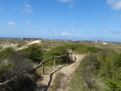 a dirt trail with a fence on a beach at Joy in Egmond-Binnen
