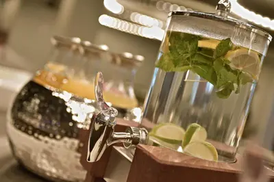 a glass vase with a drink and lime slices at Zaan Hotel Amsterdam - Zaandam in Zaandam