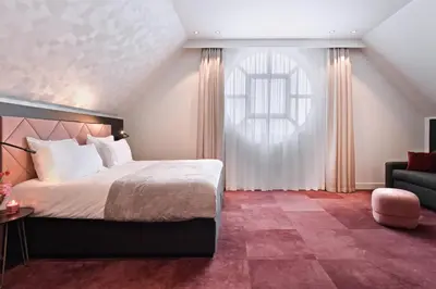 a bedroom with a bed and a chair and a window at Zaan Hotel Amsterdam - Zaandam in Zaandam