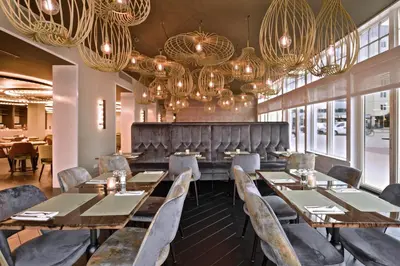 a dining room with tables and chairs and chandeliers at Zaan Hotel Amsterdam - Zaandam in Zaandam