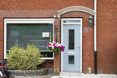 a brick house with a door and a flower pot at Beautiful family house 5 min away from Amsterdam in Badhoevedorp